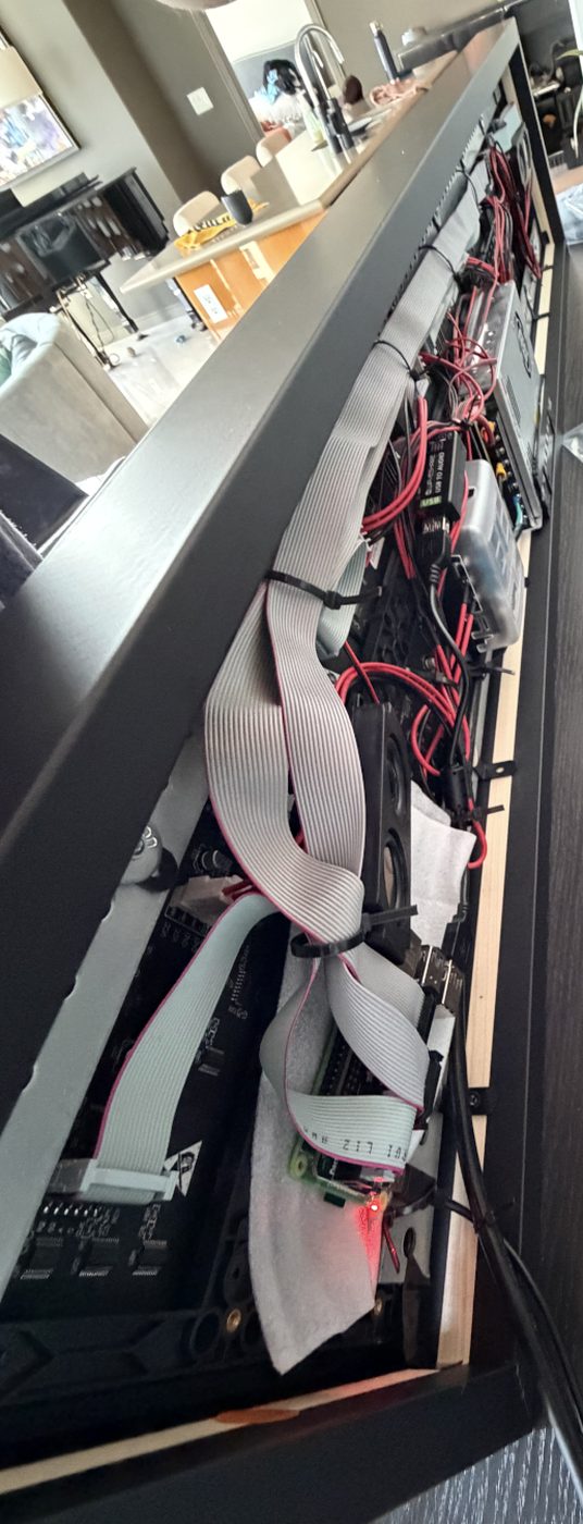 Looking along the back of the frame: ribbon cables zip-tied along the rail down to the Raspberry Pi